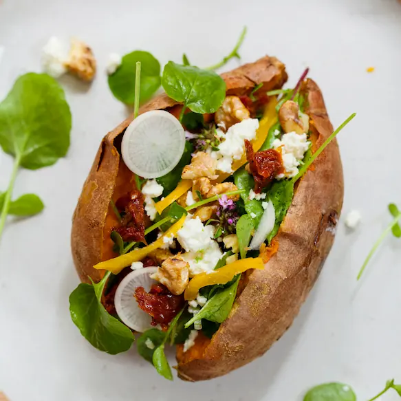 Baked sweet potato with salad stuffed inside it.